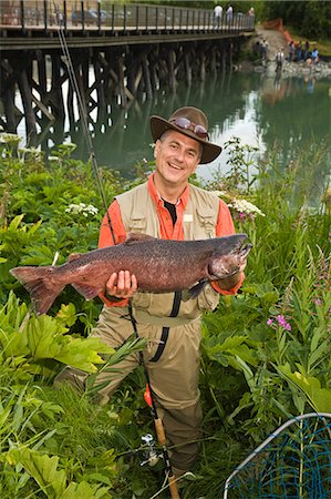 Fisherman poses with King Salmon at Ship Creek in downtown Anchorage, Alaska during Summer Fotografie stock - Rights-Managed, Codice: 854-03538042