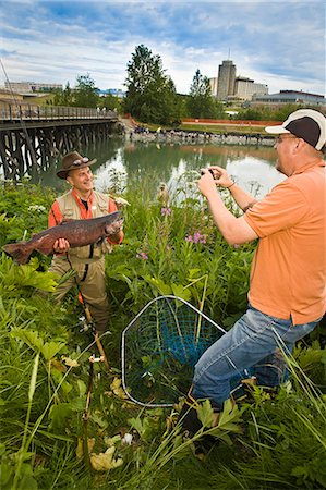 ship creek - Fisherman poses with King Salmon at Ship Creek in downtown Anchorage, Alaska during Summer Stock Photo - Rights-Managed, Code: 854-03538043