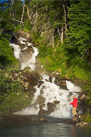 Fisherman spin fishing for salmon at the base of Fisher Falls at Big River Lakes in Redoubt Bay State Critical Habitat Area, Southcentral Alaska Stock Photo - Rights-Managed, Code: 854-03538052
