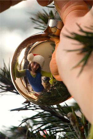 Gros plan des mains d'une femme comme elle accroche un ornement sur un arbre de Noël Photographie de stock - Rights-Managed, Code: 854-03538997