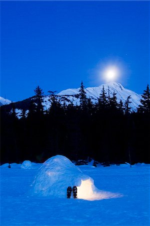 Hand built igloo in moonlight lit up with snowshoes at entrance Glacier Valley Girdwood Alaska Foto de stock - Con derechos protegidos, Código: 854-03539214