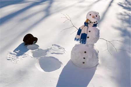 funny freezing cold photos - Snowman in forest making snow angel imprint in snow in late afternoon sunlight Alaska Winter Stock Photo - Rights-Managed, Code: 854-03539256