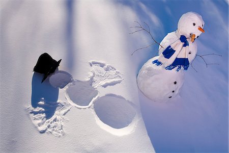 funny freezing cold photos - Snowman in forest making snow angel imprint in snow in late afternoon sunlight Alaska Winter Stock Photo - Rights-Managed, Code: 854-03539257