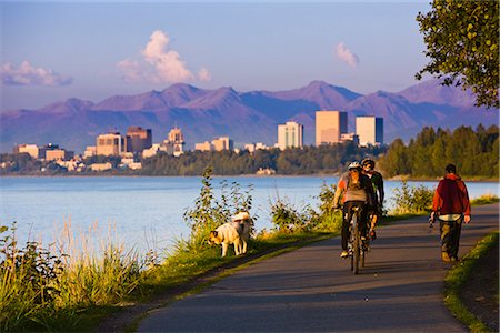 simsearch:6126-08644477,k - Personnes tenues de jogging, la marche et la bicyclette sur le sentier côtier de Tony Knowles avec skyline Downtown Anchorage dans le centre-sud distance, Anchorage, en Alaska, l'été Photographie de stock - Rights-Managed, Code: 854-03645939
