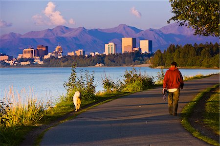 People jogging, walking and biking on the Tony Knowles Coastal Trail with Downtown Anchorage skyline in the distance, Anchorage, Southcentral Alaska, Summer Fotografie stock - Rights-Managed, Codice: 854-03645940