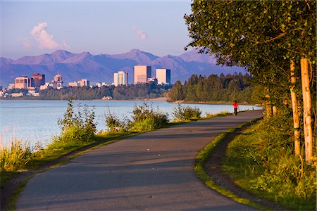 People jogging, walking and biking on the Tony Knowles Coastal Trail with Downtown Anchorage skyline in the distance, Anchorage, Southcentral Alaska, Summer Stock Photo - Rights-Managed, Code: 854-03645941