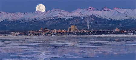 Panoramic view of moon rising over the Anchorage skyline and Chugach Mountains at dusk with  fireworks overhead as seen from Point Woronzof, Southcentral Alaska, Winter, COMPOSITE Stock Photo - Rights-Managed, Code: 854-03646388