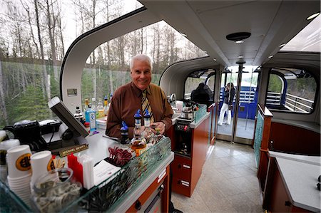 saloon - Male waiter serves refreshments for first-class passengers on the Alaska Railroad's Goldstar service between Anchorage and Seward, Southcentral Alaska, Summer Foto de stock - Con derechos protegidos, Código: 854-03646435