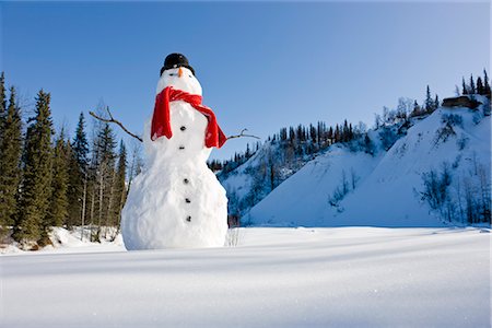 Snowman with a red scarf and black top hat sitting next to a snow covered river bed, Southcentral Alaska, Winter Foto de stock - Direito Controlado, Número: 854-03646498