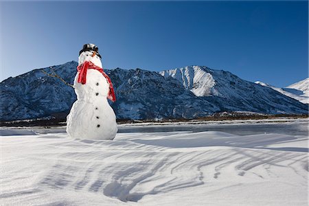 Schneemann mit einer roten Schal und schwarzen Hut sitzt auf dem gefrorenen Nenana River mit den Ausläufern der Alaskakette im Hintergrund, South Central Alaska, Winter Stockbilder - Lizenzpflichtiges, Bildnummer: 854-03646509