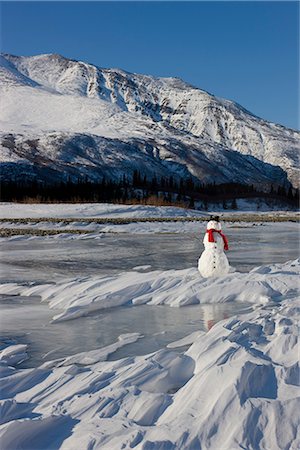 Snowman with a red scarf and black top hat sitting on the frozen Nenana River with the Alaska Range foothills in the background, Southcentral Alaska, Winter Stock Photo - Rights-Managed, Code: 854-03646519