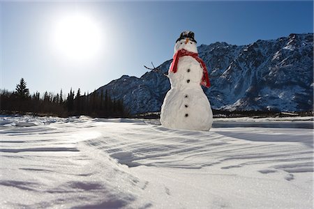 Snowman with a red scarf and black top hat sitting on the frozen Nenana River with the Alaska Range foothills in the background, Southcentral Alaska, Winter Foto de stock - Con derechos protegidos, Código: 854-03646513