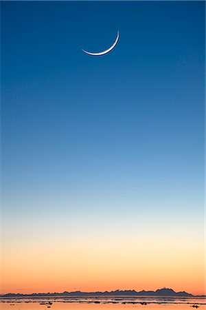 Cresent moon rising at sunset over Cook Inlet near Elderberry Park in Anchorage, Southcentral Alaska, Winter, COMPOSITE Stock Photo - Rights-Managed, Code: 854-03646719