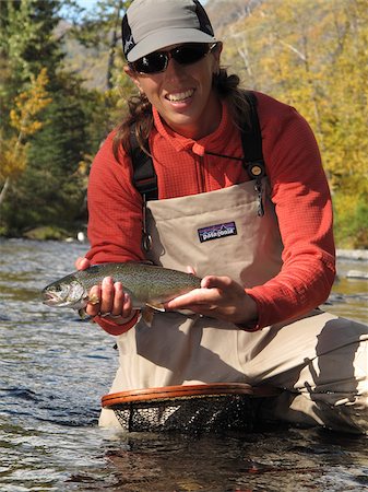 Woman holds and shows off a Rainbow Trout caught while fly fishing on the Russian River, Kenai Peninsula, Southcentral Alaska, Autumn Foto de stock - Con derechos protegidos, Código: 854-03739501