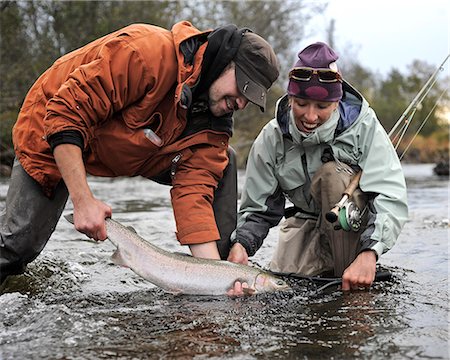 simsearch:854-02954996,k - Man and woman kneeling in water to show off a wild Steelhead caught in Deep Creek, Kenai Peninsula, Southcentral Alaska, Autumn Stock Photo - Rights-Managed, Code: 854-03739524