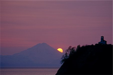 View across Cook Inlet of  Mt. Redoubt and a lighthouse at sunset,/nSouthcentral Alaska, Summer Stock Photo - Rights-Managed, Code: 854-03739640