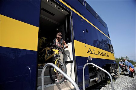 Female bicyclist disembarks from Alaska Railroad's Chugach Explorer for a whistle stop trip to Spencer Glacier, Southcentral Alaska, Summer Foto de stock - Con derechos protegidos, Código: 854-03739660