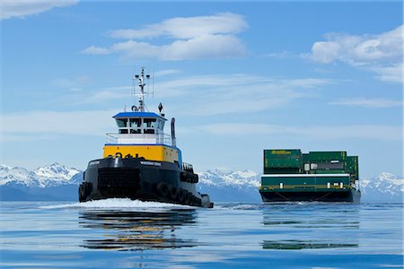 A tug pulling a barge cruises through the Inside Passage on its way south from Skagway, Alaska. Lynn Canal, Alaska Marine Lines. Stock Photo - Rights-Managed, Code: 854-03739856