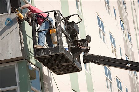simsearch:854-03739877,k - Male worker installs siding during renovation of McKinley Tower aprtments (formerly the MacKay Building) in downtown Anchorage, Southcentral Alaska, Summer Foto de stock - Con derechos protegidos, Código: 854-03739882