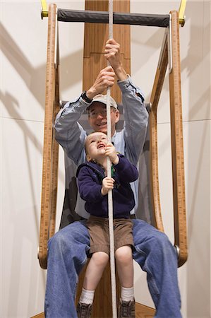 pull up man - Grandfather and toddler grandson sit together and lift themselves with a rope and pulley system at the Imaginarium, Anchorage Museum at the Rasmuson Center, Southcentral Alaska, Summer Stock Photo - Rights-Managed, Code: 854-03740016