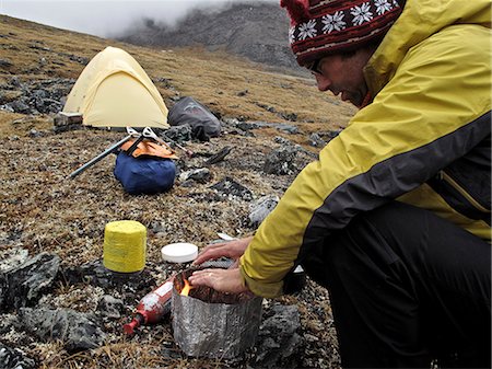 Backpacker prepares food at camp below Mt. Chamberlin, Brooks Range, ANWR, Arctic Alaska, Summer Stock Photo - Rights-Managed, Code: 854-03740048