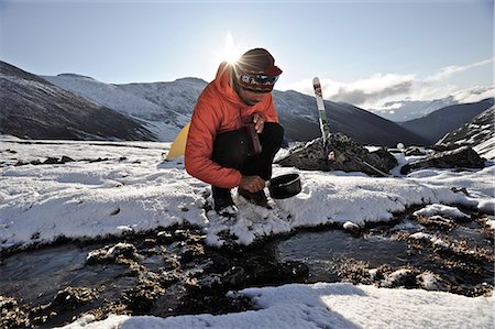 filling - Backpacker fills pan with water from a creek at an alpine camp below Mt. Chamberlin, Brooks Range, ANWR, Arctic Alaska, Summer Stock Photo - Rights-Managed, Code: 854-03740061