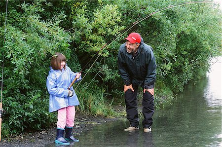 Grandfather encourages grandaughter as she battles a Pink salmon in Ingram Creek off the Seward Highway, Southcentral Alaska, Summer Foto de stock - Con derechos protegidos, Código: 854-03740165