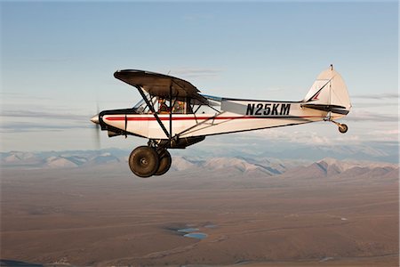 Vue aérienne d'un avion Piper Super Cub survolant la rivière Jago et la toundra de la plaine côtière de l'ANWR avec les montagnes de Romanzof en arrière-plan, l'Arctique de l'Alaska, l'été Photographie de stock - Rights-Managed, Code: 854-03740247