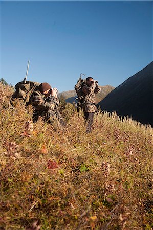 sports outdoor autumn - Two male moose hunters stop to glass the area with binoculars as they hike out of hunt area with trophy moose antlers on their packs, Bird Creek drainage area, Chugach Mountains, Chugach National Forest, Southcentral Alaska, Autumn Stock Photo - Rights-Managed, Code: 854-03845070