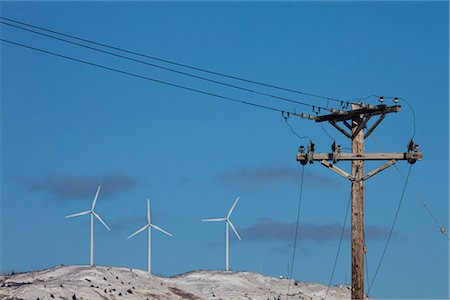 recurso natural - Pillar Mountain Wind Project wind turbines stand on Pillar Mountain on Kodiak Island with electric poles and lines in the foreground, Southwest Alaska, Winter Foto de stock - Con derechos protegidos, Código: 854-03845218