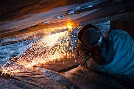 Worker cuts metal fittings off a boat hull using an oxy-acetylene cutting torch, Kodiak Boatyard, Saint Herman Harbor, Kodiak, Near Island, Southwest Alaska, Autumn Stock Photo - Rights-Managed, Code: 854-03845278
