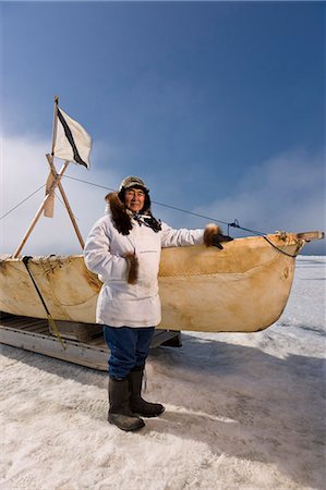 Mâle chasseur Inupiaq Eskimo, debout à côté d'un Inupiaq Umiaq fait de peau de phoque barbu (Ugruk), tout en portant une parka traditionnelle des Esquimaux (Atigi) et le sceau peau hat, mer des Tchouktches près de Barrow, Alaska Arctique, été Photographie de stock - Rights-Managed, Code: 854-03845438