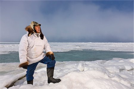 Chasseur de Inupiaq Eskimo mâle debout sur une crête de pression de glace tout en portant une parka traditionnelle des Esquimaux (Atigi) et seal skin hat, mer des Tchouktches près de Barrow, Alaska arctique, été Photographie de stock - Rights-Managed, Code: 854-03845445