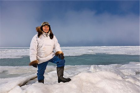 Chasseur de Inupiaq Eskimo mâle debout sur une crête de pression de glace tout en portant une parka traditionnelle des Esquimaux (Atigi) et seal skin hat, mer des Tchouktches près de Barrow, Alaska arctique, été Photographie de stock - Rights-Managed, Code: 854-03845443
