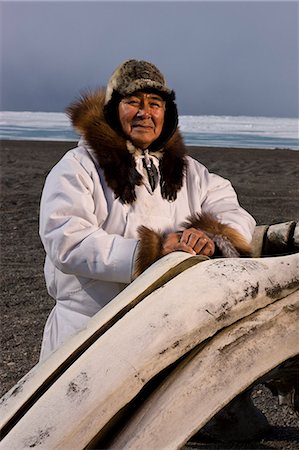 parka - Mâle chasseur Inupiaq Eskimo debout derrière une baleine boréale le long de la mer des Tchouktches portant son parka (Atigi) esquimau, chapeau de peau de phoque et de loup Maklak la peau avec des semelles en peau de phoque barbu (Ugruk), de Barrow, Alaska arctique, été Photographie de stock - Rights-Managed, Code: 854-03845450