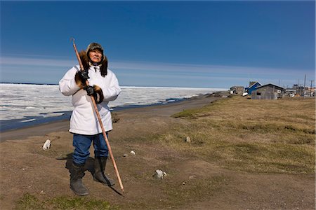 simsearch:851-02963922,k - Portrait d'un chasseur Inupiaq Eskimo mâle portant son parka Eskimo (Atigi) et un chapeau de peau de phoque et tenant un bâton de marche à Utkeagvik ancien lotissement original avec vue sur la mer des Tchouktches, Barrow, Alaska arctique, l'été Photographie de stock - Rights-Managed, Code: 854-03845472