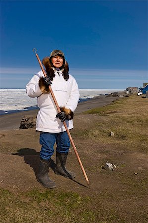 Portrait of a male Inupiaq Eskimo hunter wearing his Eskimo parka (Atigi) and seal skin hat and holding a walking stick at Old Utkeagvik original town site overlooking the Chukchi Sea, Barrow, Arctic Alaska, Summer Stock Photo - Rights-Managed, Code: 854-03845473