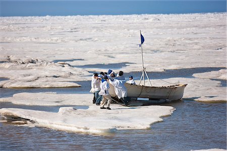 Équipage de chasse à la baleine pousse leur Umiaq la glace de mer de Chuchki à la fin de la saison de la chasse printanière à Barrow, Alaska arctique, été Photographie de stock - Rights-Managed, Code: 854-03845491