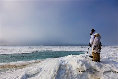 Männliche und weibliche Inupiak Eskimo Jäger tragen ihre Eskimo-Parka (Atigi) tragen ein Gewehr und Gehstock beim Blick auf die Tschuktschensee, Barrow, Alaska Arktis, Sommer Stockbilder - Lizenzpflichtiges, Bildnummer: 854-03845509