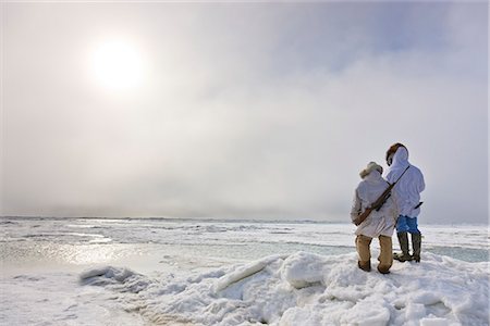 simsearch:854-03845521,k - Male and female Inupiaq Eskimo hunters wearing their Eskimo parka's (Atigi) carry a rifle and walking stick while looking out over the Chukchi Sea, Barrow, Arctic Alaska, Summer Foto de stock - Con derechos protegidos, Código: 854-03845511