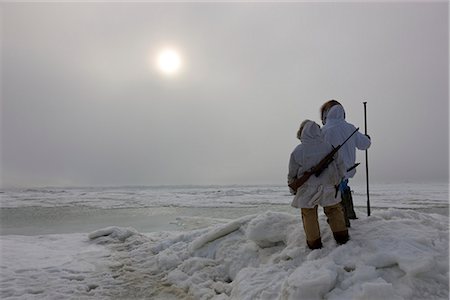 Mâles et femelles Inupiaq Eskimo chasseurs portant leur parka Eskimo (Atigi) portent un fusil et un bâton de marche tout en surplombant la mer des Tchouktches, Barrow, l'Alaska arctique, été Photographie de stock - Rights-Managed, Code: 854-03845513