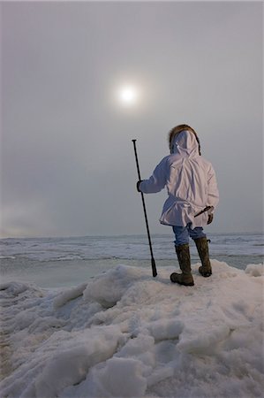 eskimo with gun - Male Inupiaq Eskimo hunter wearing his Eskimo parka (Atigi) and carrying a walking stick while looking out over the Chukchi Sea, Barrow, Arctic Alaska, Summer Stock Photo - Rights-Managed, Code: 854-03845522