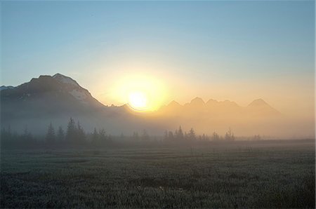 Morning fog hangs on the ground near the Copper River Highway as the sun rise over the Chugach Mountains, Chugach National Forest, Southcentral Alaska, Spring. HDR Fotografie stock - Rights-Managed, Codice: 854-03846115