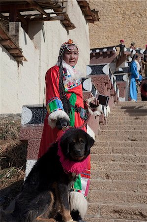 simsearch:855-06312870,k - A Yunnan woman in traditional costume with a dog at Songzanlin Temple, Shangri-la, China Foto de stock - Direito Controlado, Número: 855-06312869