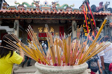 Worshipper offering incense at Pak Tai Temple during the Bun festival, Cheung Chau, Hong Kong Stock Photo - Rights-Managed, Code: 855-06313352