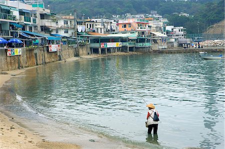 A man fishing at Yung Shu Wan Bay,Lamma Island,Hong Kong Fotografie stock - Rights-Managed, Codice: 855-03021890