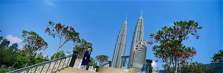 University graduate taking photos in the park with Patrons Towers at background, Kuala Lumpur, Malaysia Foto de stock - Con derechos protegidos, Código: 855-03253695