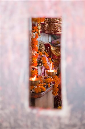 Burning oil lamps in a temple viewed through a slot in wall, Chandi Temple, Haridwar, Uttarakhand, India Photographie de stock - Rights-Managed, Code: 857-06721447