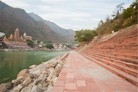 rishikesh - Steps on ghat at River Ganges with Lakshman Jhula and Trayambakeswar temple in the background, Lakshman Jhula, Rishikesh, Dehradun District, Uttarakhand, India Stockbilder - Lizenzpflichtiges, Bildnummer: 857-06721512