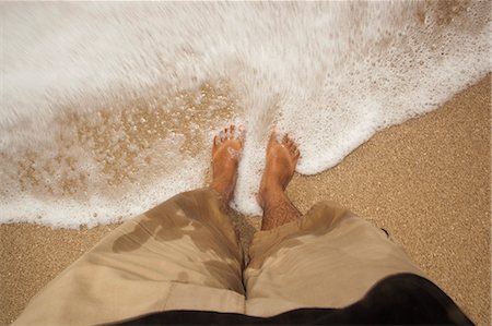 photography looking down at feet - Low section view of a man standing on the beach surf, Dwarka Beach, Dwarka, Gujarat, India Stock Photo - Rights-Managed, Code: 857-06721685